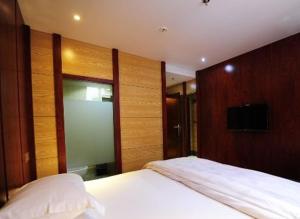 a bedroom with a large white bed with wooden walls at JUNYI Hotel Guizhou Guiyang Bageyan Road in Guiyang