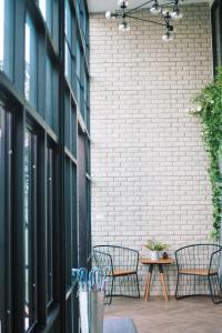 a patio with two chairs and a table in front of a brick wall at Baan Noppadol in Bangkok