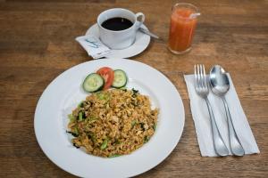 a plate of food with rice and vegetables and a cup of coffee at Anggie Stay in Kerobokan