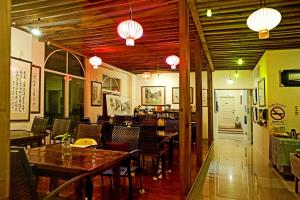 Un restaurante con techos de madera y mesas y sillas. en The Rippling Vale Homestay, en Puli