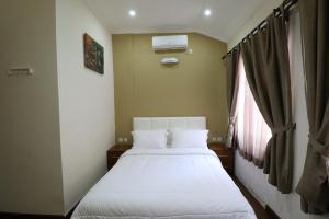 1 dormitorio con 2 camas y ventana en Diyar Villas Puncak M6/14, en Puncak