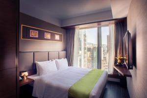 una camera d'albergo con un letto e una grande finestra di Soravit on Granville a Hong Kong