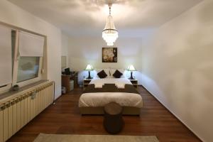 a bedroom with a large bed and a chandelier at Apartmani "Mimoza" in Otočac