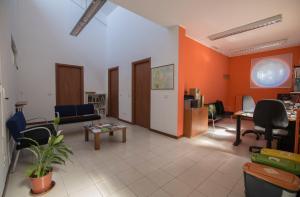 チニゼッロ・バルサモにあるLa Cordata Accommodation - Brodolini 24のオレンジ色の壁のリビングルーム(ソファ、椅子付)