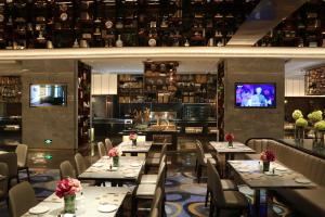 a dining room with tables and chairs and a television at Rongjiang Hotel in Jieyang