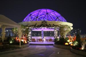a lit up gazebo with tables and chairs at night at Rongjiang Hotel in Jieyang