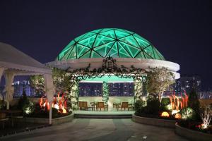 a gazebo with chairs and a fountain at night at Rongjiang Hotel in Jieyang