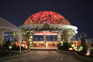 a gazebo with chairs and a fountain at night at Rongjiang Hotel in Jieyang