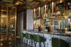 a bar with green chairs in a restaurant at Rongjiang Hotel in Jieyang