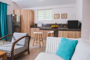 a living room with a couch and a kitchen at Coconuts in Grand Baie