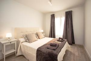 プラヤ・オンダにあるFlower Beach Suite 7の白いベッドルーム(スリッパ2枚付)