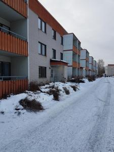 a snow covered street in front of a building at Borlänge Hostel and Apartments in Borlänge