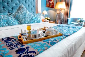 a tray of food and drinks on a bed at Marina Byblos Hotel in Dubai