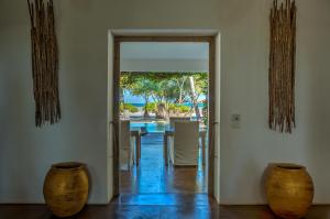 an open door to a dining room with a table and chairs at Uzuri Boutique Hotel in Jambiani