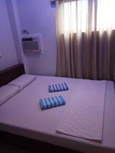 a bed with two pillows on it in a room at Anthurium Inn in Mactan
