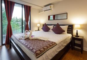 Un dormitorio con una cama con dos cisnes encima. en The Aristo by Holy Cow, 2-BR loft, 90 m2, pool view, en Surin Beach 23 fotos más