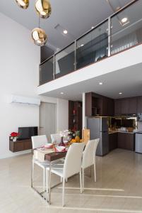 Una cocina y un comedor con mesa y sillas. en The Aristo by Holy Cow, 2-BR loft, 90 m2, pool view, en Surin Beach