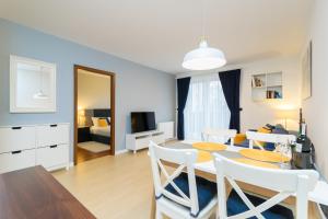 a dining room and living room with a table and chairs at Apartament Darłówko in Darlowko