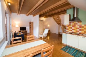 a kitchen and living room with a table and chairs at Apartments Rožič Bohinj in Bohinj