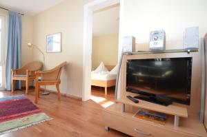 ein Wohnzimmer mit einem Flachbild-TV auf einem Stand in der Unterkunft Villa Seerose - Appartement 05 in Ostseebad Sellin