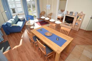 ein Wohnzimmer mit einem Tisch und einem blauen Sofa in der Unterkunft Villa Seerose - Appartement 05 in Ostseebad Sellin