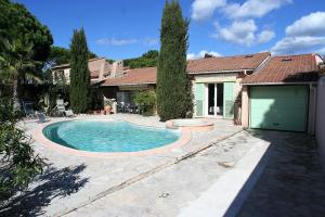 a swimming pool in front of a house at villa avec jacuzzi in Sainte-Maxime