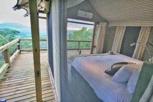 Muluwa Lodge في وايت ريفر: غرفة نوم مع سرير على شرفة