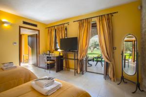 a bedroom with a bed and a tv and a mirror at Mystras Grand Palace Resort & Spa in Mystras