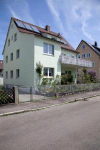 uma casa branca com uma cerca ao lado de uma rua em Haus Josefine em Friedrichshafen