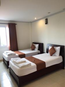 um quarto de hotel com duas camas e uma janela em Nhu Ngoc Homestay em Ấp Thiện Phước