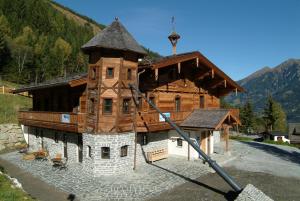 a large wooden building with a large roof at MONDI Schiefe Alm Gastein in Bad Gastein