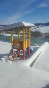 a table with a roof in the snow at Drevenica Kvietok in Liptovská Kokava