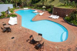 una gran piscina con sillas, mesa y sillas en St Michaels Sands Hotel & Time Share Resort, en Shelly Beach