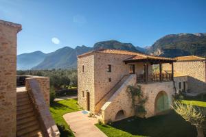 a building with a balcony and mountains in the background at Mystras Grand Palace Resort & Spa in Mystras