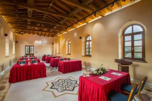 a row of tables in a room with red table cloths at Mystras Grand Palace Resort & Spa in Mystras +80 photos