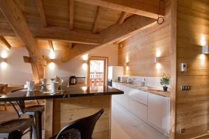 ラルプ・デュエズにあるOdalys Chalet Nuance de grisの木製の壁のキッチン(テーブル、椅子付)