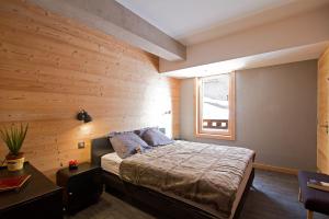 ラルプ・デュエズにあるOdalys Chalet Nuance de bleuの木製の壁のベッドルーム1室