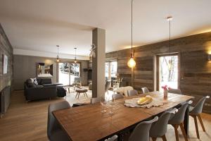 a dining room and living room with a table and chairs at Odalys Chalet Nuance de blanc in L'Alpe-d'Huez