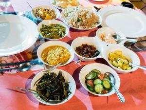 a table full of bowls of food on a table at ViNiSH iNN in Nallathanniya