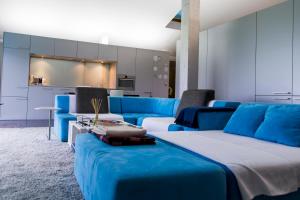 a living room with blue couches and a kitchen at Habitaciones amplias tipo Suite Durango in Guyuria