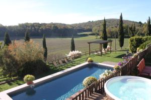 a swimming pool in a garden with a view at Villa Le Caggia in Sovicille