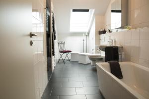 e bagno con vasca, servizi igienici e lavandino. di Appartementhaus Elm Immobilien a Königslutter am Elm