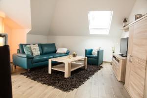 un soggiorno con divano e tavolo di Appartementhaus Elm Immobilien a Königslutter am Elm