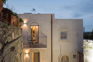 a white house with a balcony with a table on it at Jasmine Holiday Villa in Episkopí- Rethimno