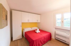 ポルト・ロトンドにあるResidenze Dei Fioriの赤いベッドと動物の詰め物が置かれたベッドルーム1室
