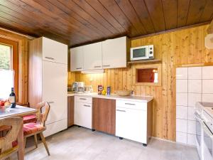 ハイリゲンブルートにあるFerienhaus mit Kaminofen A 650.014の木製の天井、白い家電製品付きのキッチン