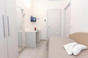 a white bedroom with a bed and a sink at Hotel Tourist Meuble in Rimini