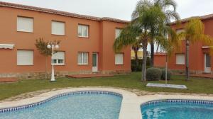 a swimming pool in front of a building at Apartamento entero 3 Habitaciones CLUB SEVILLA III in Casas Devesa