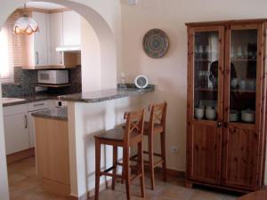 a kitchen with a table and two chairs and a counter at Apartamento entero 3 Habitaciones CLUB SEVILLA III in Casas Devesa