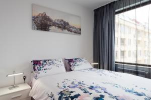 a bedroom with a bed and a large window at Grand Vitosha Apartments in Sofia